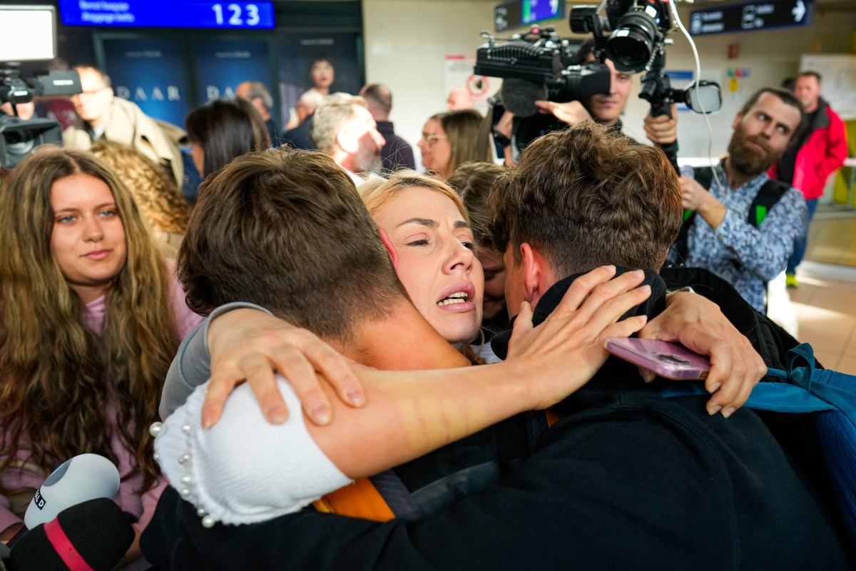 March 6: A family hugs after disembarking from an evacuation flight on a commercial airplane from Muscat, Oman, at the Henri Coanda International Airport in Otopeni, Romania.