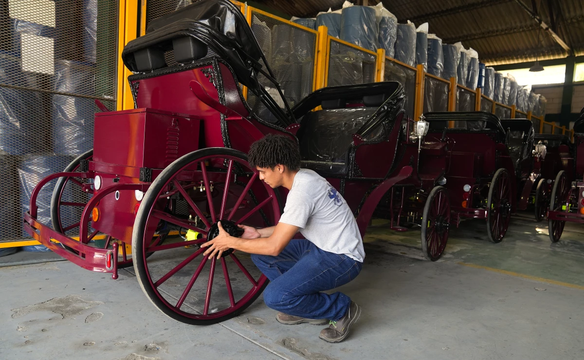 A worker fixes a wheel on one of the electric carriages that Cartagena's municipal government has imported from China.