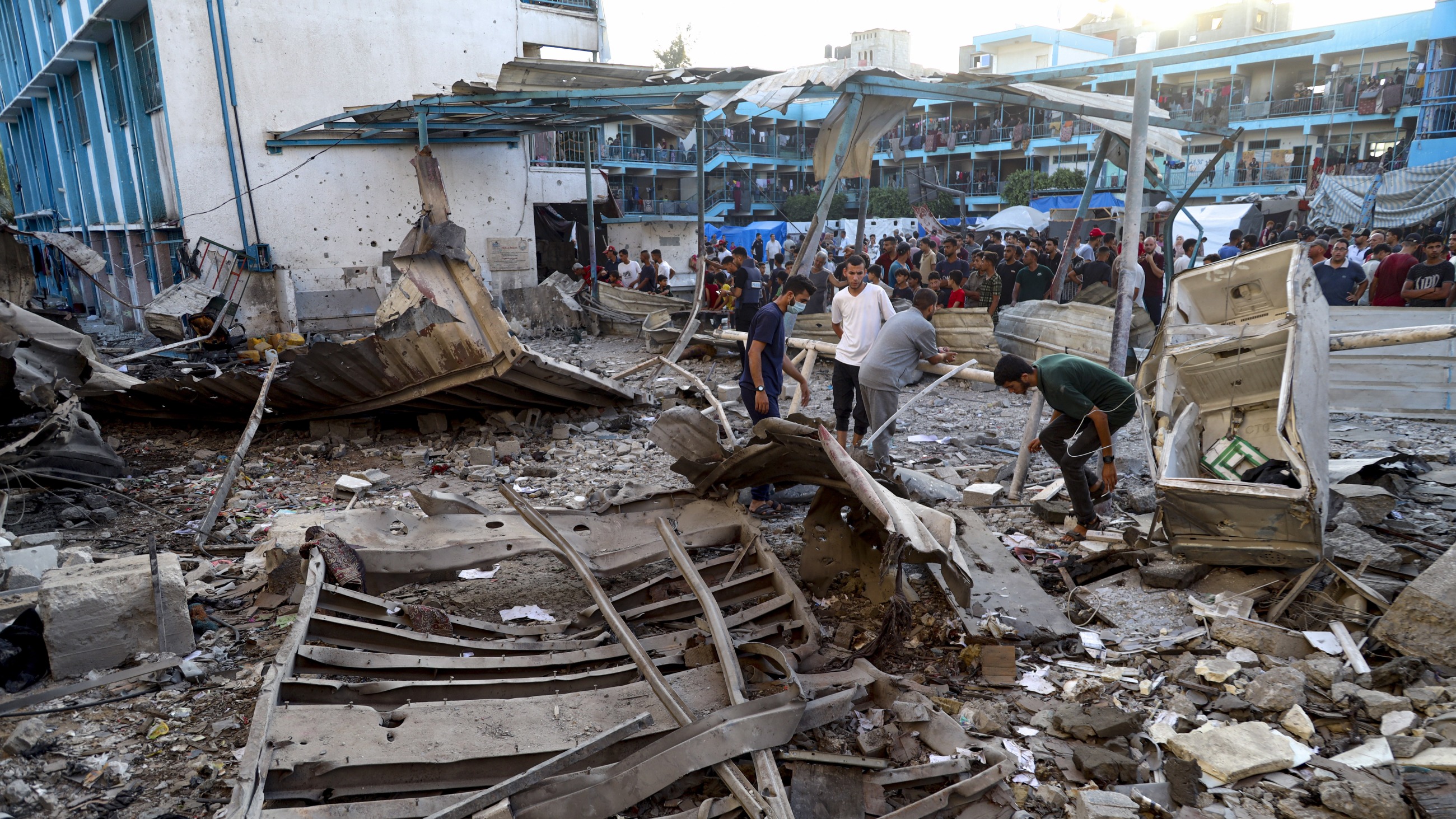 Palestinians look at the aftermath of the Israeli airstrike on a U.N.-run school in the Nuseirat refugee camp in the Gaza Strip, Saturday, July 6.