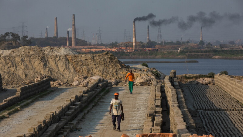 Smoke comes out from kiln at a brickfield on the outskirt of Dhaka, Bangladesh on February 6, 2021. The world is going through a speedy urbanization and Bangladesh is not an exception from this. Such rapid urbanization generates a massive demand for bricks as it is one of the key ingredients to build concrete structure. To meet this growing need, numbers of brick making field have been increasing at an alarming rate in Bangladesh. Most of them took place in farming lands which causes reduction of agricultural production. We know that burning coal causes tremendous emission of Carbon-Di-Oxide (CO2) gas which is primarily responsible for climate change. Brick making fields use coal as fuel to burn raw bricks. Burning coal is also foremost cause of acid rain, and toxic air pollution. Workers work here from dawn to dusk still their wage is not up to the minimum standard.