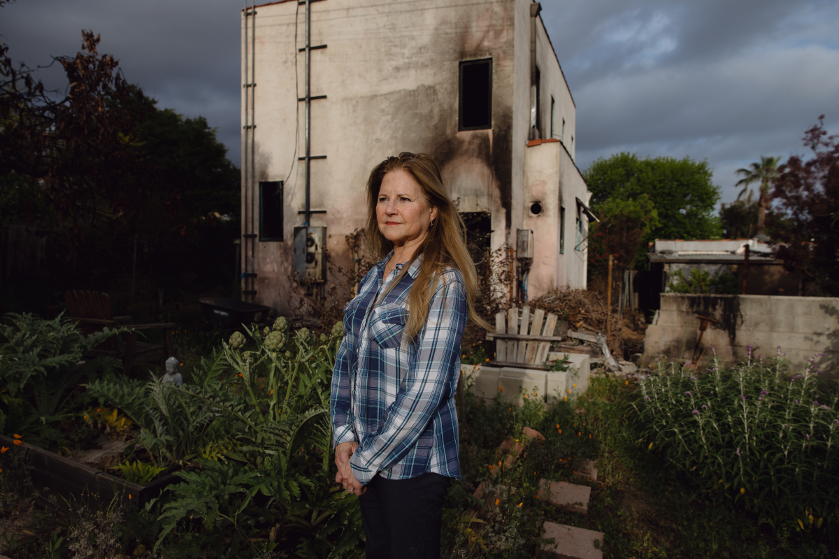 Lea Chazin stands in front of her home in Altadena, which was damaged by the Eaton Fire.