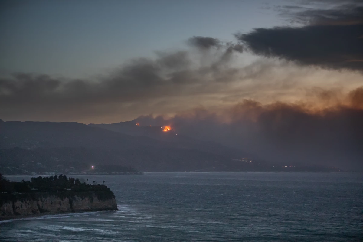 Smoke from the Palisades Fire is seen from Point Dume while it burns homes along the Pacific Coast Highway amid a powerful windstorm on Wednesday in Malibu, California. Fueled by intense Santa Ana winds, the Palisades Fire has burned through thousands of acres while a second major fire continues to burn near Eaton Canyon in Altadena.