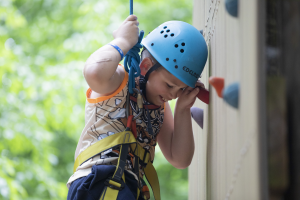 Christopher Currid climbs the rock wall at Camp Cranium.