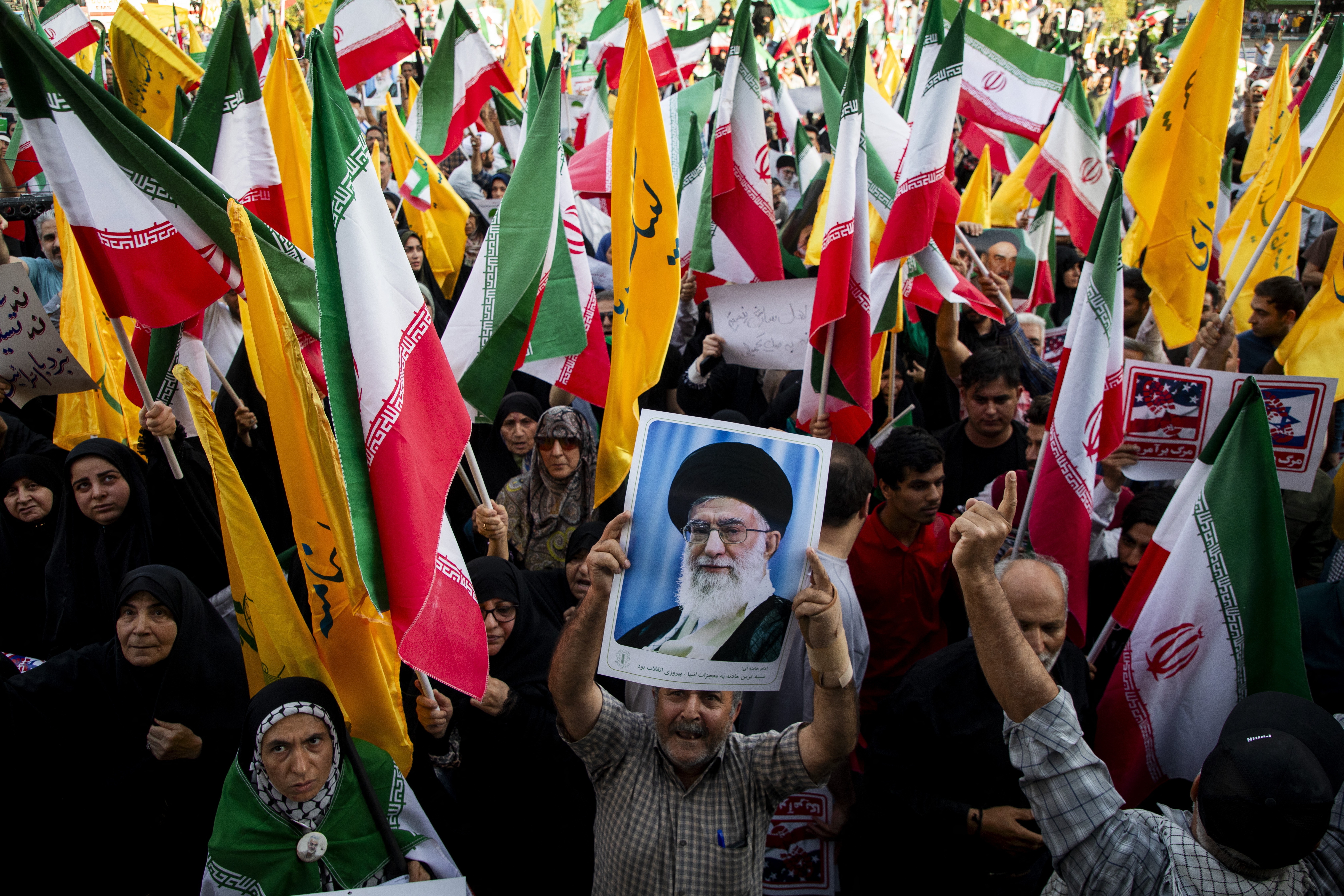 People hold flags of Iran and Hezbollah as well as posters of Supreme Leader Khamenei as Iranians take to the streets in the downtown Enghelab (Revolution) Square in Tehran, Iran on June 24, 2025, to celebrate the ceasefire after a 12-day war with Israel.