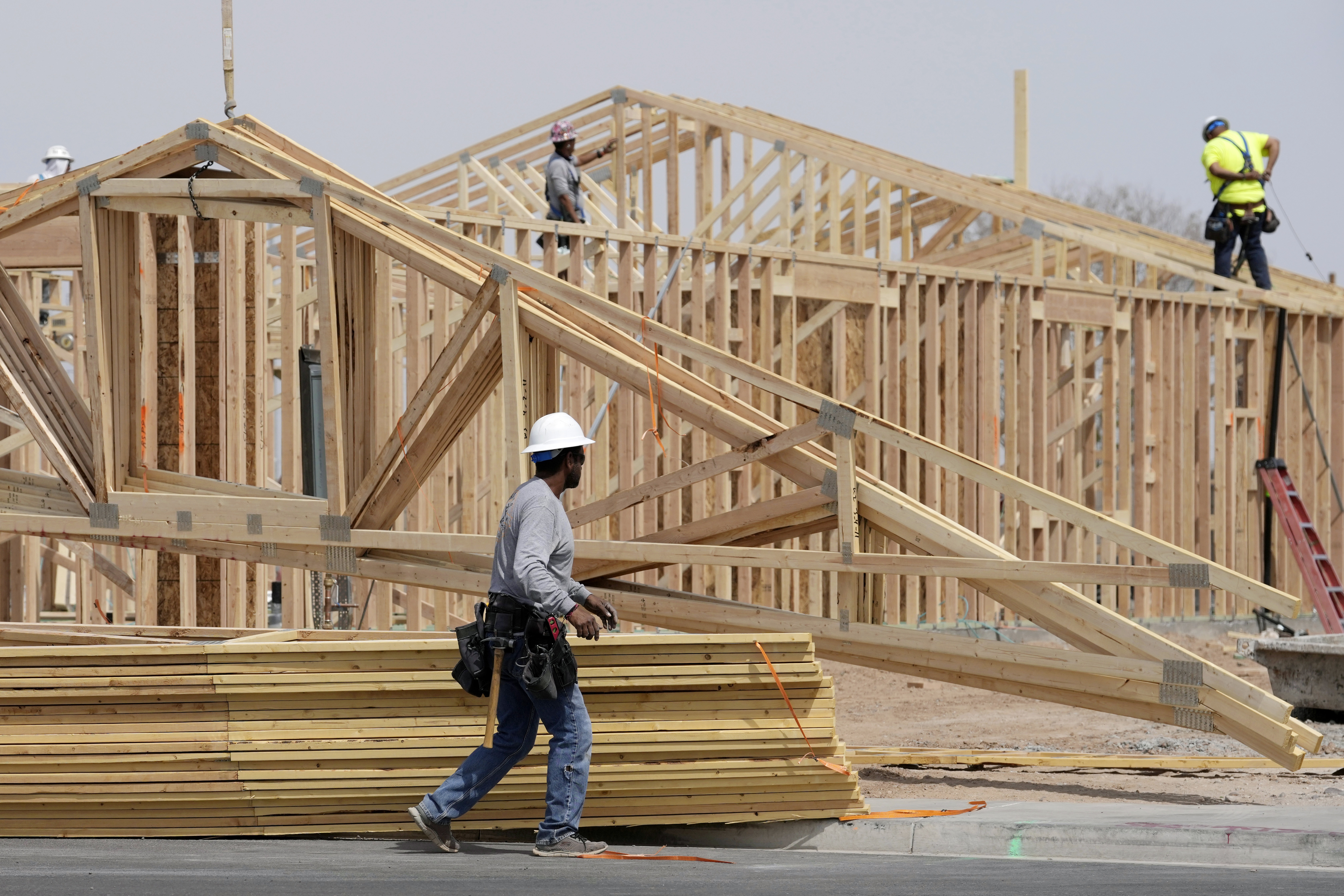 Homebuilding has slowed as Americans face economic uncertainty and high mortgage rates. Here, construction workers install a lumber roof on a new home last month in Laveen, Ariz. (AP)