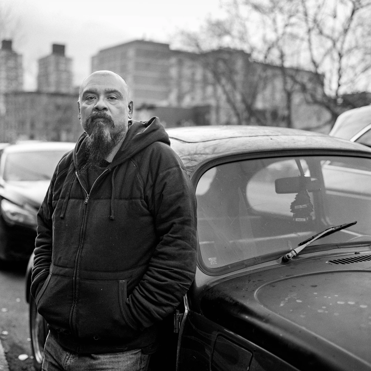 Andrés Lucero poses for a portrait beside his Volkswagen Beetle on Aug. 21, 2024.
