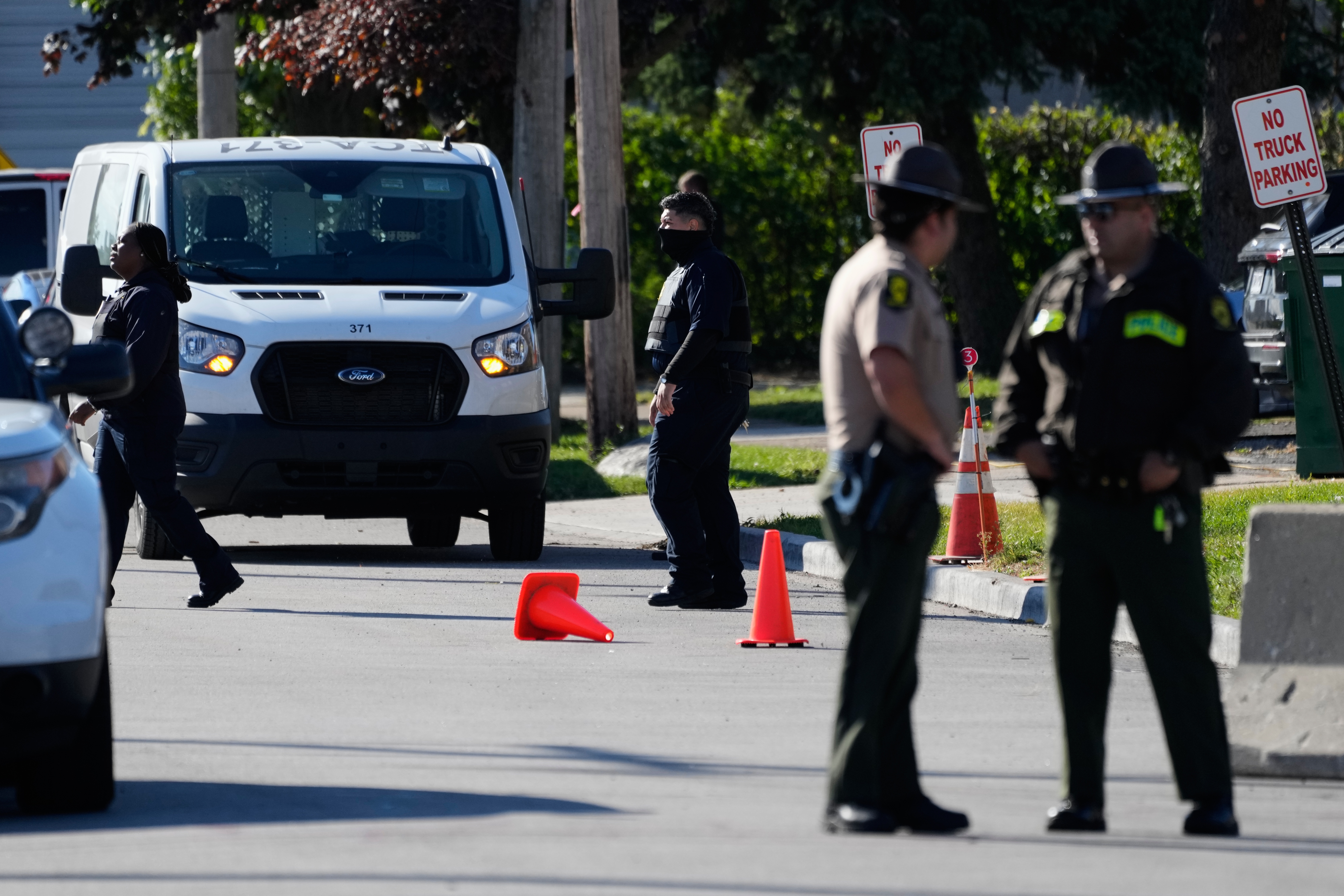 A federal agent, center, walks to his vehicle outside an ICE processing facility in the Chicago suburb of Broadview, Ill., on Oct. 21, 2025.