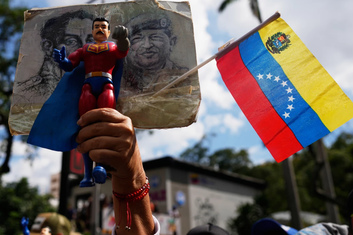 A government supporter holds an action figure of Super Bigote during a protest demanding the release of President Nicolas Maduro, who was captired by U.S. forces,  in Caracas, Venezuela, Sunday, Jan. 4.