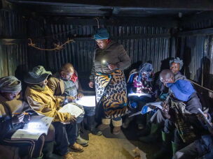 Mampho Makha teaches students at a rudimentary night school in the village of Ha Ntsokoane in Thaba Tseka, Lesotho. Many of the students are shepherds who missed out on formal schooling during childhood. The school operates on a shoestring budget and lacks electricity, so students study by the light of their phones.