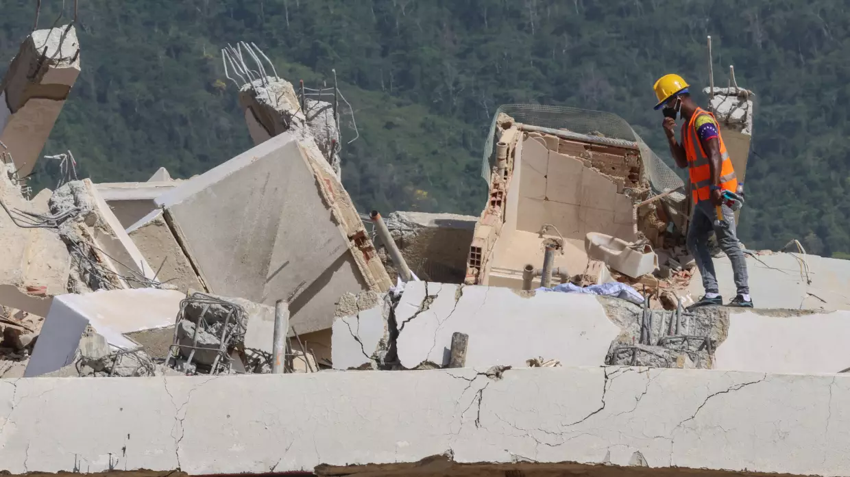 A person searches for victims on June 27 amid debris of a collapsed building after powerful earthquakes struck Venezuela, in Los Corales, Venezuela.