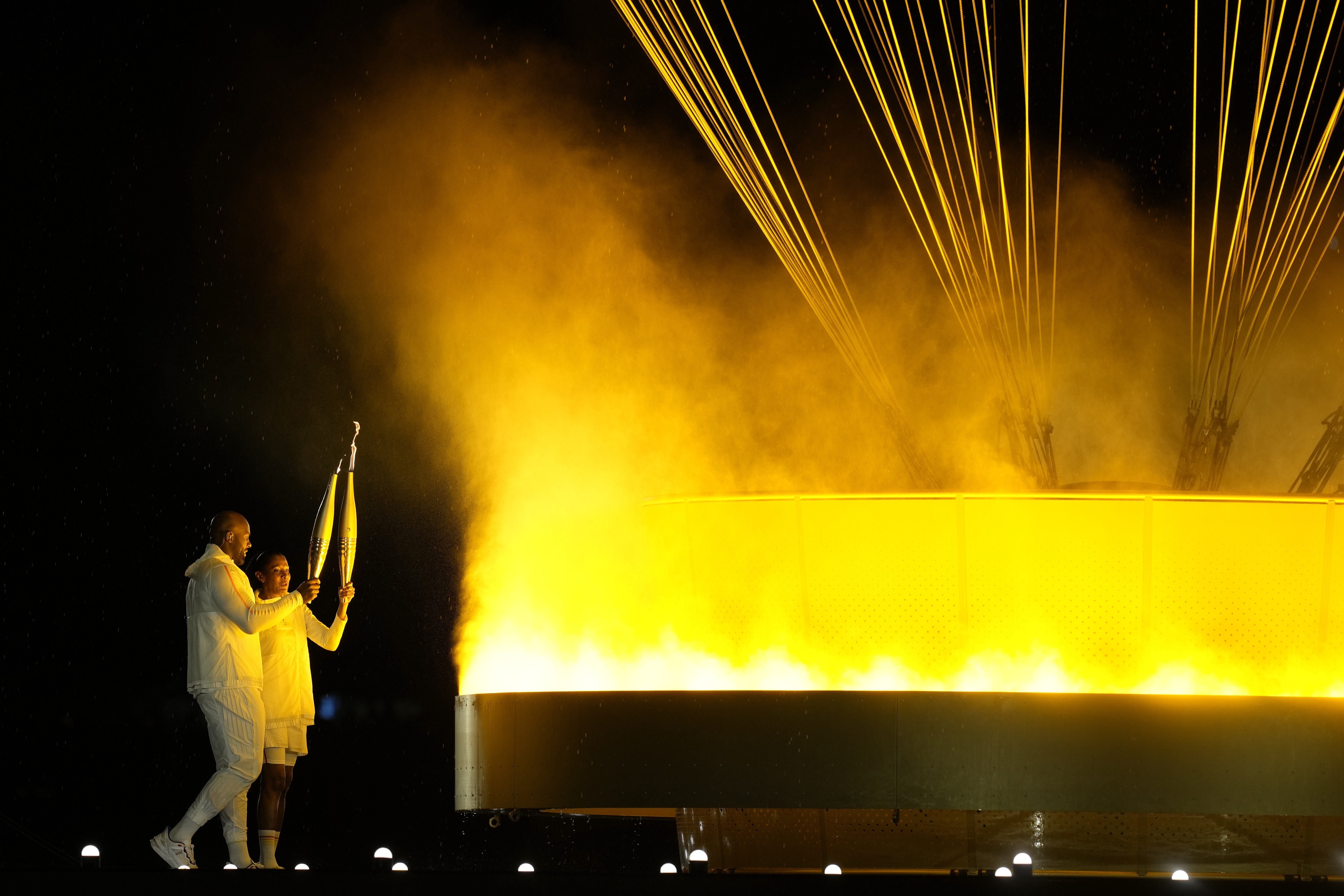 The cauldron is lit by torch bearers Marie-Jose Perec and Teddy Riner in Paris, during the opening ceremony of the 2024 Summer Olympics, Friday, July 26, 2024. (AP)