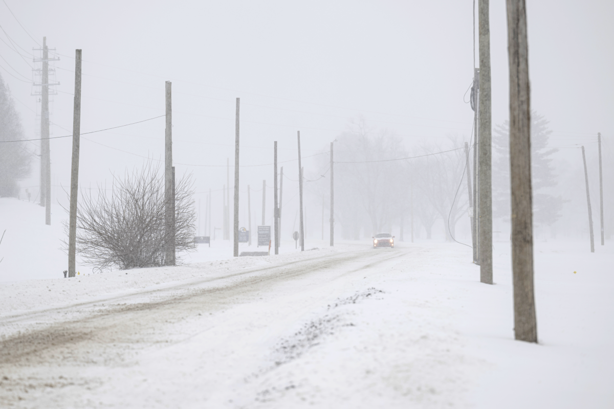 A vehicle drives through snowy conditions on Sunday in Louisville, Ky.