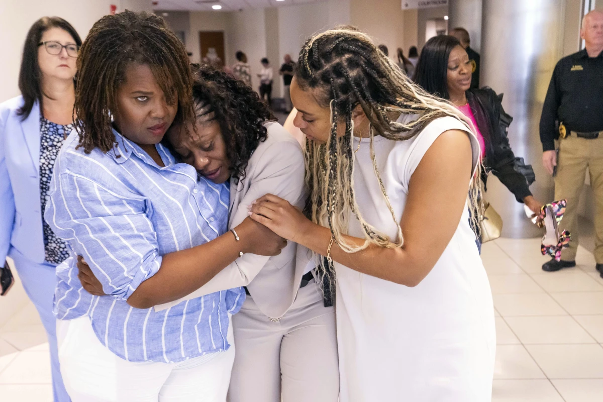 Pamela Dias (center), Ajike “A.J.” Owens' mother, is consoled by friends and family outside the courtroom after a jury found Susan Lorincz guilty of manslaughter in the shooting death of her daughter, Friday afternoon in Ocala, Fla.