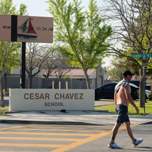 A man walks March 19 past Cesar Chavez Elementary School in Bakersfield, Calif.