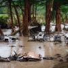 Wrecked vehicles and trailers along the Guadalupe River in Kerrville, Texas.