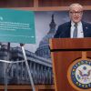 参议院少数党领袖查克·舒默(Chuck Schumer)在新闻发布会上站在画架旁边。