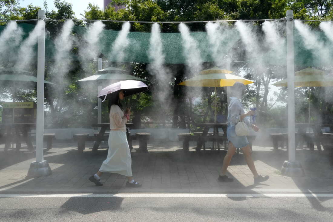 Visitors pass by the cooling fog device at Gwangmyeong Cave tourist site in Gwangmyeong, South Korea, Aug. 6, 2026.