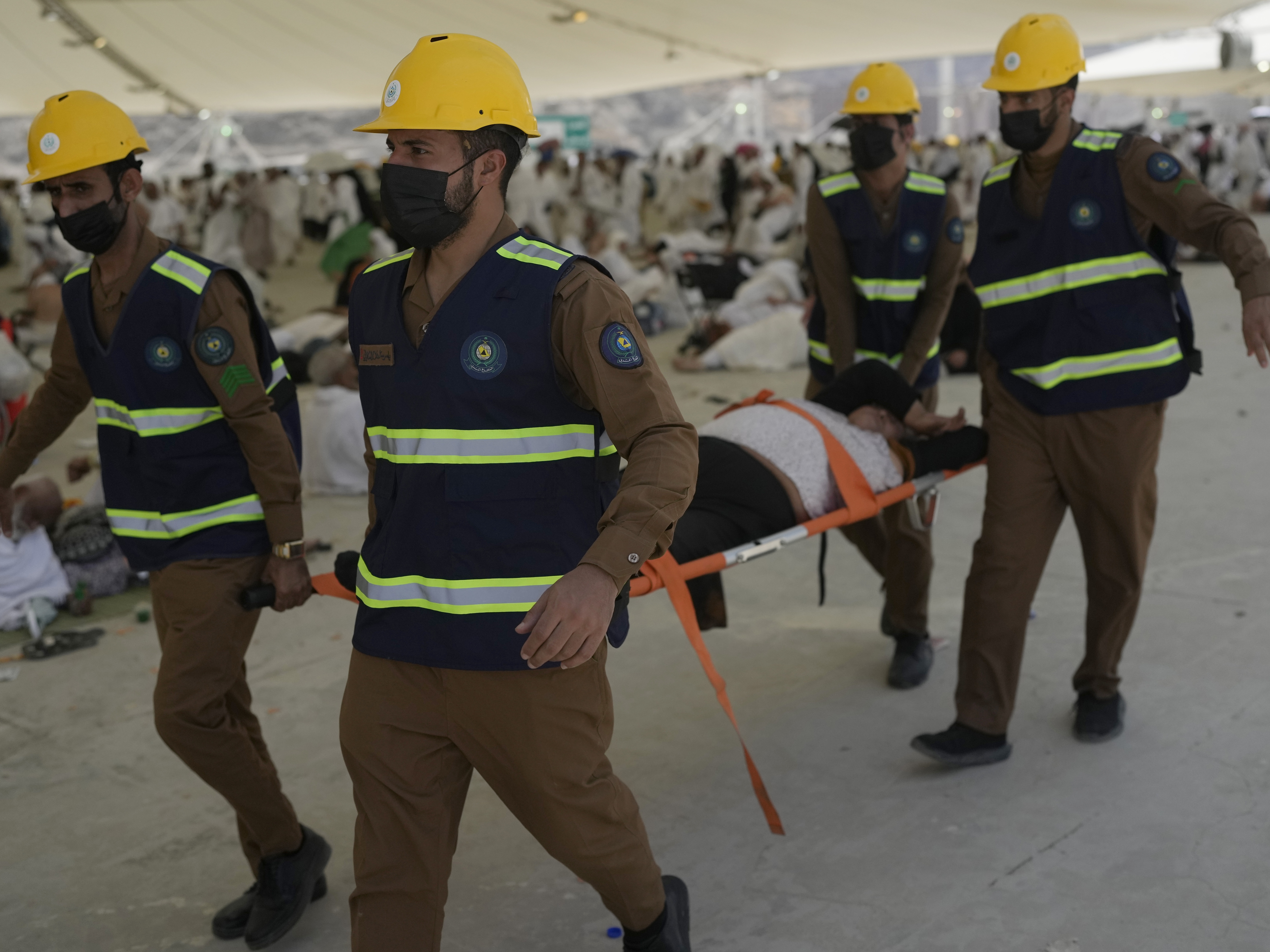 Paramedics carry a Muslim pilgrim for a medical check after he fell down due to a heat stroke near the holy city of Mecca, Saudi Arabia, on Sunday, June 16, 2024. Masses of pilgrims on Sunday embarked on a symbolic stoning of the devil in Saudi Arabia, which marks the final days of the Hajj, or Islamic pilgrimage, and the start of the Eid al-Adha celebrations for Muslims around the world.