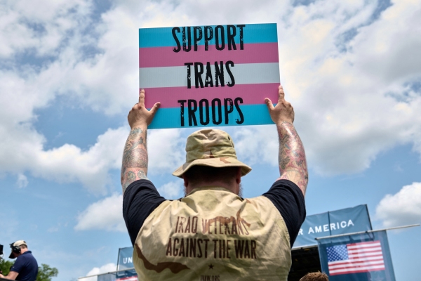 A person holds a sigh supporting transgender veterans at the Unite For Veterans rally on the National Mall in Washington D.C. in June 2025.