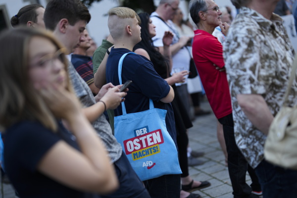 A German with a bag reading "The east does it" attends an election campaign rally of the far-right Alternative for Germany, AfD, in Suhl, Germany, Aug. 13.