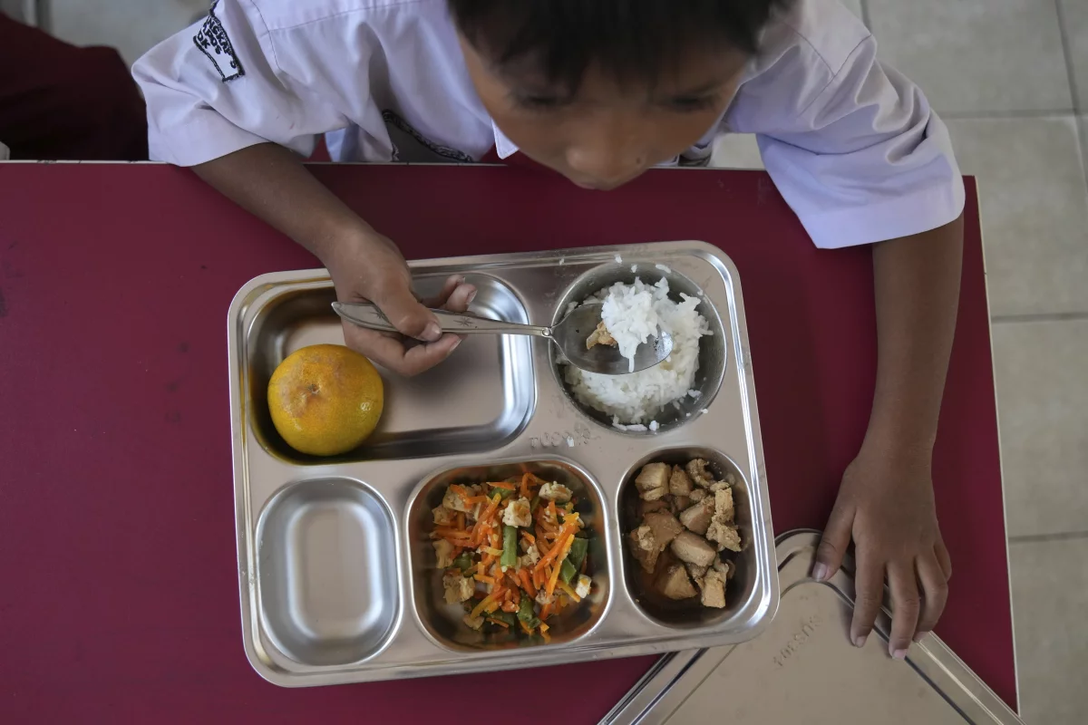 A student has his meal during the kick off of President Prabowo Subianto's ambitious free meal program to feed children and pregnant women nationwide — despite critics saying that its required logistics could hurt Indonesia's state finances and economy — at an elementary school in Depok, West Java, Indonesia, Monday, Jan. 6, 2025.