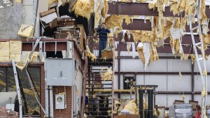 William Fraser takes photographs inside the warehouse of a damaged building of Specialty Distributors after severe weather passed through an industrial park on Thursday in Jeffersontown, Ky.