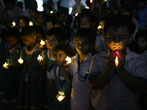 School students hold LED candles as they gather to pay their homage to people who died in Nepal's flash flood, in Chennai.