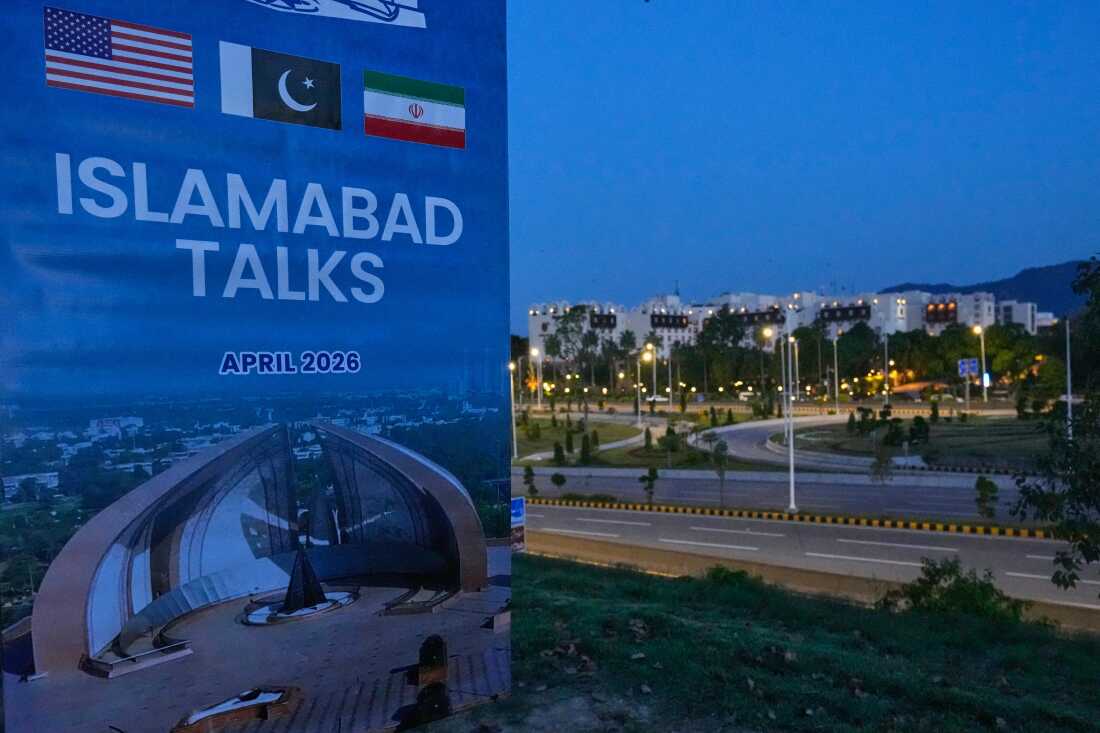 A billboard of the U.S. Iran talks is seen near Serena Hotel, the venue for the U.S. Iran officials meeting, in Islamabad, Pakistan, Sunday, April 12, 2026.