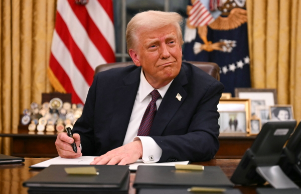 President Trump signs executive orders in the Oval Office of the White House on January 20.