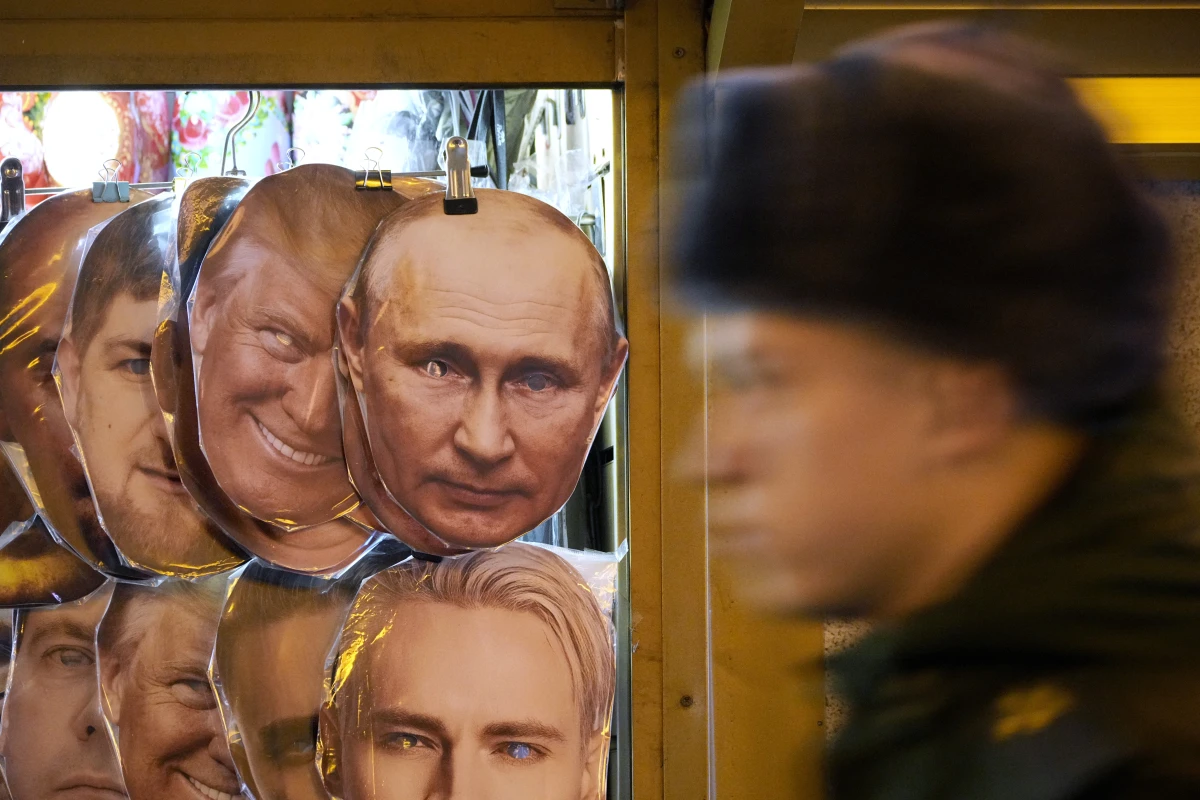 A Russian serviceman walks past face masks depicting Donald Trump and Vladimir Putin for sale at a souvenir shop in St. Petersburg, Russia, on Wednesday.