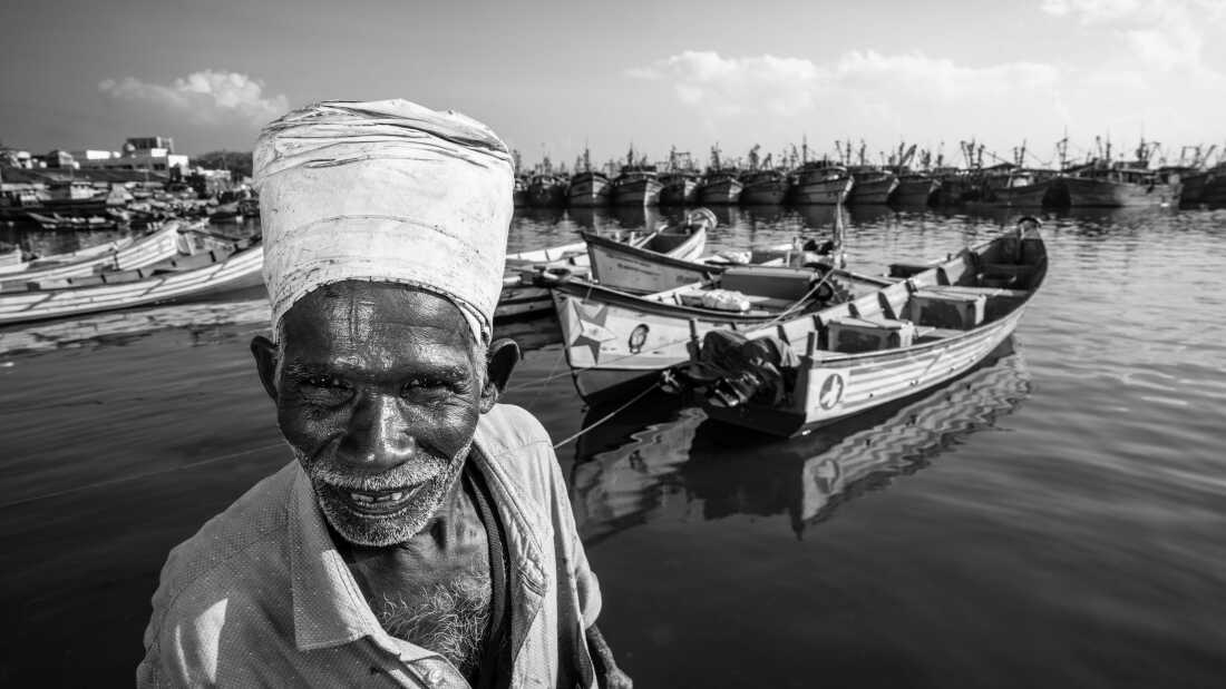 Pavadairayan, 60, a migrant laborer known as a “basket man,” carries fish from boats to the auction house at Kasimedu Fishing Harbour in Chennai, India.