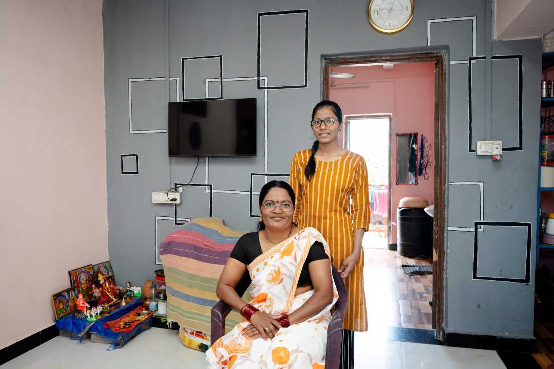 Savitha Yadava and her daughter 42, Poonam 19 pose in their living room, adjacent to a kitchen and the bedroom behind them. There's a small shrine in one corner. Moving into their new home helped the children secure good grades and well-paying jobs. Decorating her home has now become a passion she says.