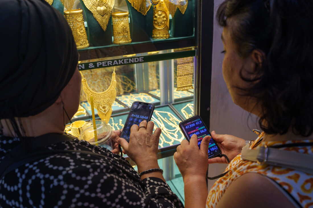Women use their phones to calculate exchange rates before buying gold at the Grand Bazaar in Istanbul, Turkey, on Aug. 20, 2026.