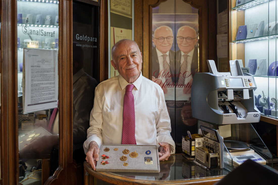 Gold expert and market analyst Mehmet Ali Yıldırımtürk holds a display tray of historical and modern gold coins at his shop inside the Grand Bazaar in Istanbul, Turkey, on Aug. 26, 2026. The collection includes traditional Ottoman-era coins, such as Reşat and Hamit gold in the middle, alongside modern Turkish Republic coins, including Ata and ribboned Çeyrek gold on the left. On the right is a 1-gram gold piece, which was introduced to the market in 2016 as a more affordable way for people to buy gold.