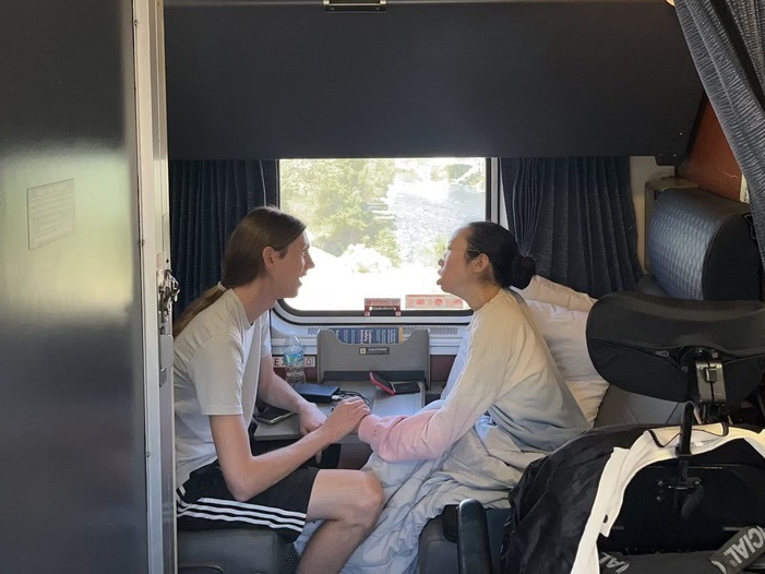 Peter Saathoff-Harshfield and Aubrie Lee hold hands while in their accessible room on the California Zephyr Amtrak train.