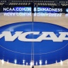 The NCAA logo is displayed in 2015 at the center of the basketball court at The Consol Energy Center in Pittsburgh, with a March Madness ad displayed on sideline screens behind it.