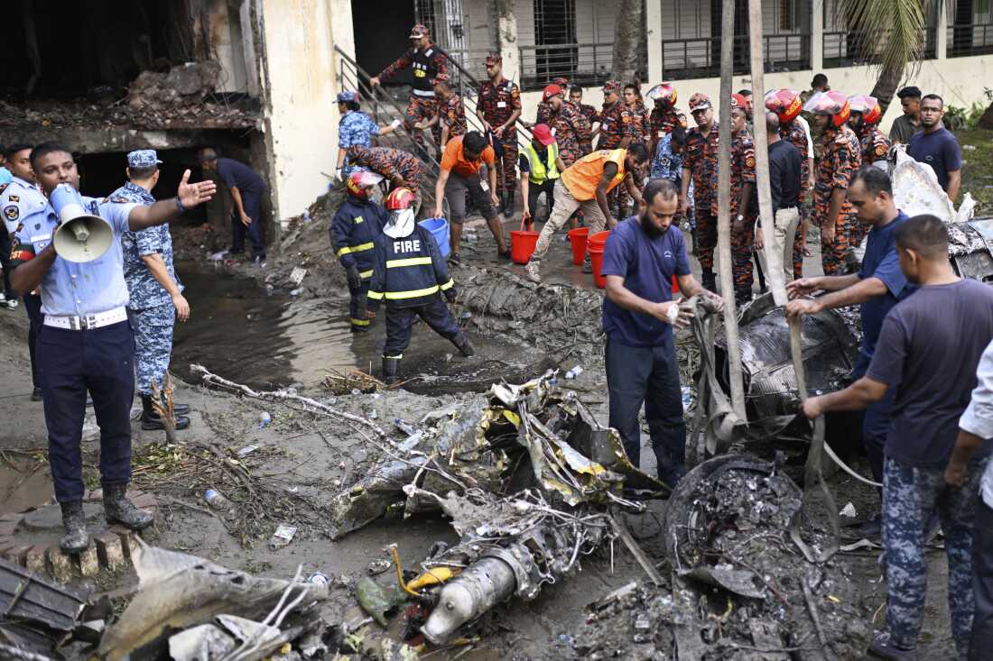 Firefighters work at the site of a Bangladesh Air Force training aircraft that crashed into a school campus shortly after takeoff in Dhaka, Bangladesh, Monday.