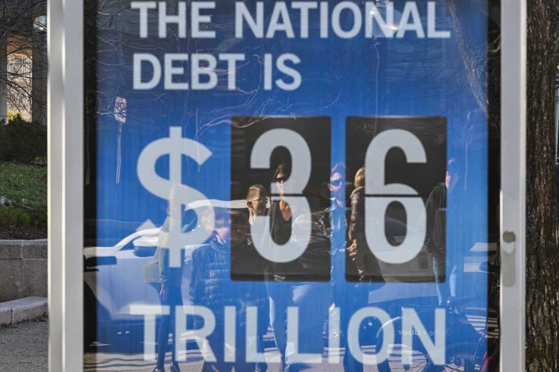 A National Debt Clock billboard display shows the United States gross national debt and each American family's share of the debt in Washington, DC, on December 30, 2024. The Congressional Budget Office has stated that the U.S. national debt is poised to top $56 trillion by 2034, as rising spending and interest expenses outpace tax revenues. The mounting costs of Social Security and Medicare continue to weigh on the nation's finances, along with rising interest rates, which have made it more costly for the federal government to borrow huge sums of money. (Photo by ROBERTO SCHMIDT / AFP) (Photo by ROBERTO SCHMIDT/AFP via Getty Images)