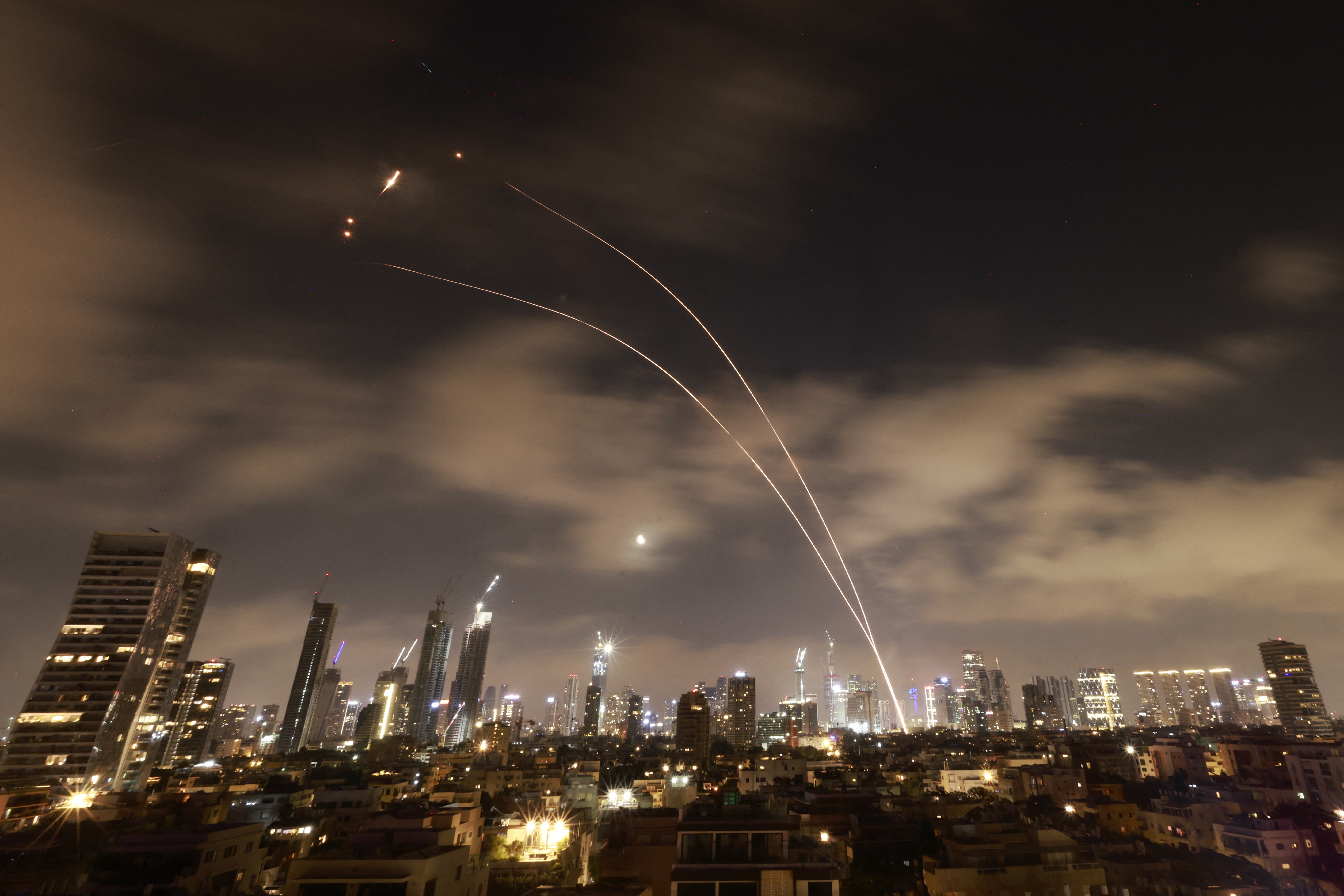 Israeli air defense systems fire to intercept Iranian missiles over Tel Aviv before dawn Wednesday. Israel and Iran exchanged fire for a sixth day.