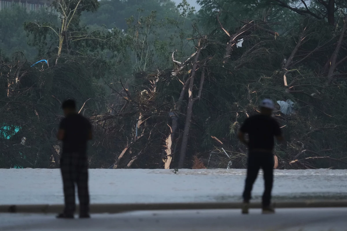 Onlookers survey damage caused along the Guadalupe River after a flash flood swept through the area in Kerrville, Texas.