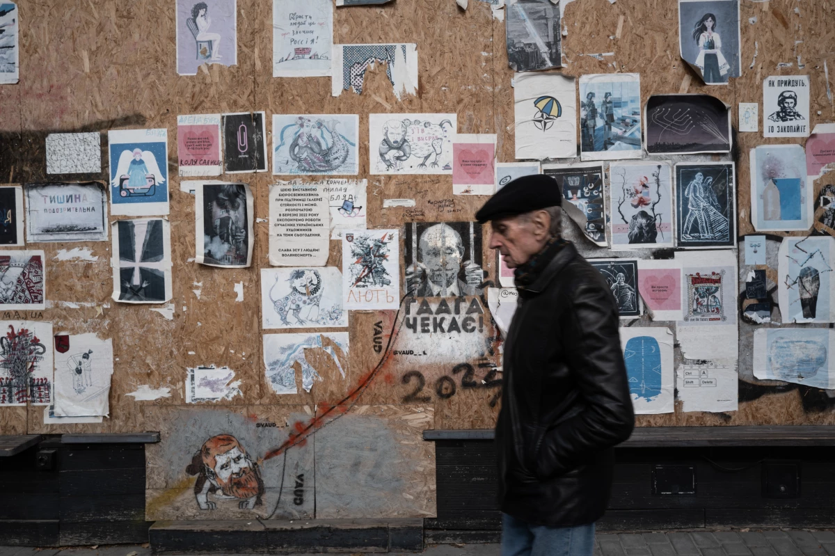A man passes a boarded-up building covered in anti-Russia posters in Odesa, Ukraine, on Oct. 27, 2024. Anti-Russian sentiment runs high throughout Ukraine, but it runs up against a rich Russian cultural tradition in Odesa. The historical city was once a huge draw for Russian tourists, especially during the Soviet era. Russian is still spoken widely, but Ukrainians are making a concerted effort to erase the Russian legacy of the region.