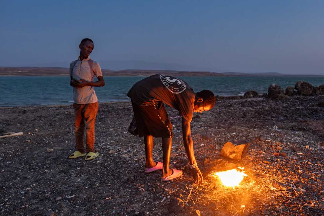 An El Molo youth stokes a fire that was lit as part of a traditional ritual hoped to bring fish and rain, on Komote Island in Lake Turkana in northern Kenya. Declining fish stocks and flooding have had a huge impact on the El Molo, one of Africa's smallest ethnic groups who now number no more than a few hundred, and whose way of life is entirely reliant on the lake.