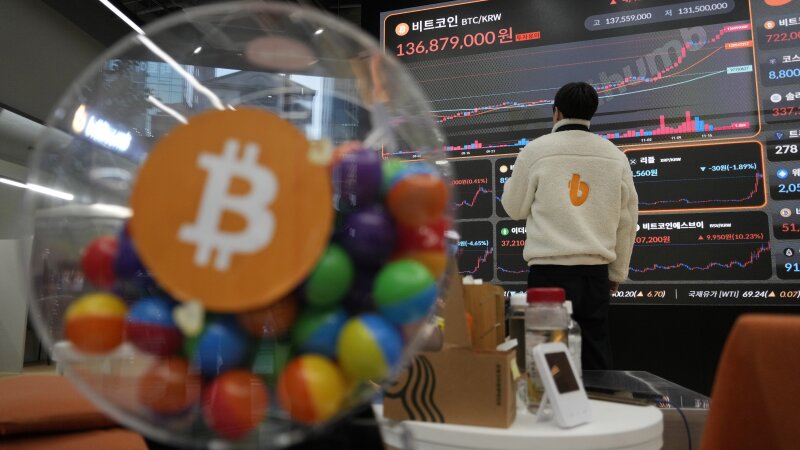 FILE - An employee watches an electronic signboard displaying the prices of Bitcoin and other cryptocurrencies at the lounge of Bithumb cryptocurrency exchange in Seoul, South Korea, Nov. 21, 2024.