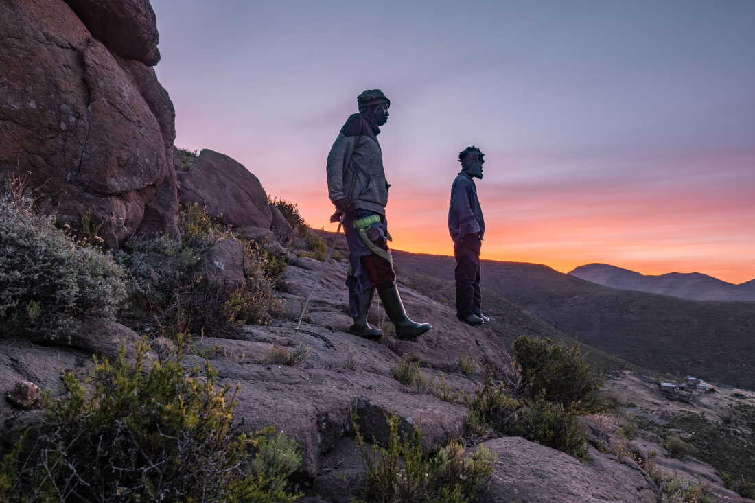 Shepherds Lapeli Maapesa and Kabelo Mohai take a break while trekking down from their cattle posts in the mountains to attend class at the Good Shepherd night school in Semonkong, Lesotho. Some shepherds walk for as long as two hours to attend their nightly classes.