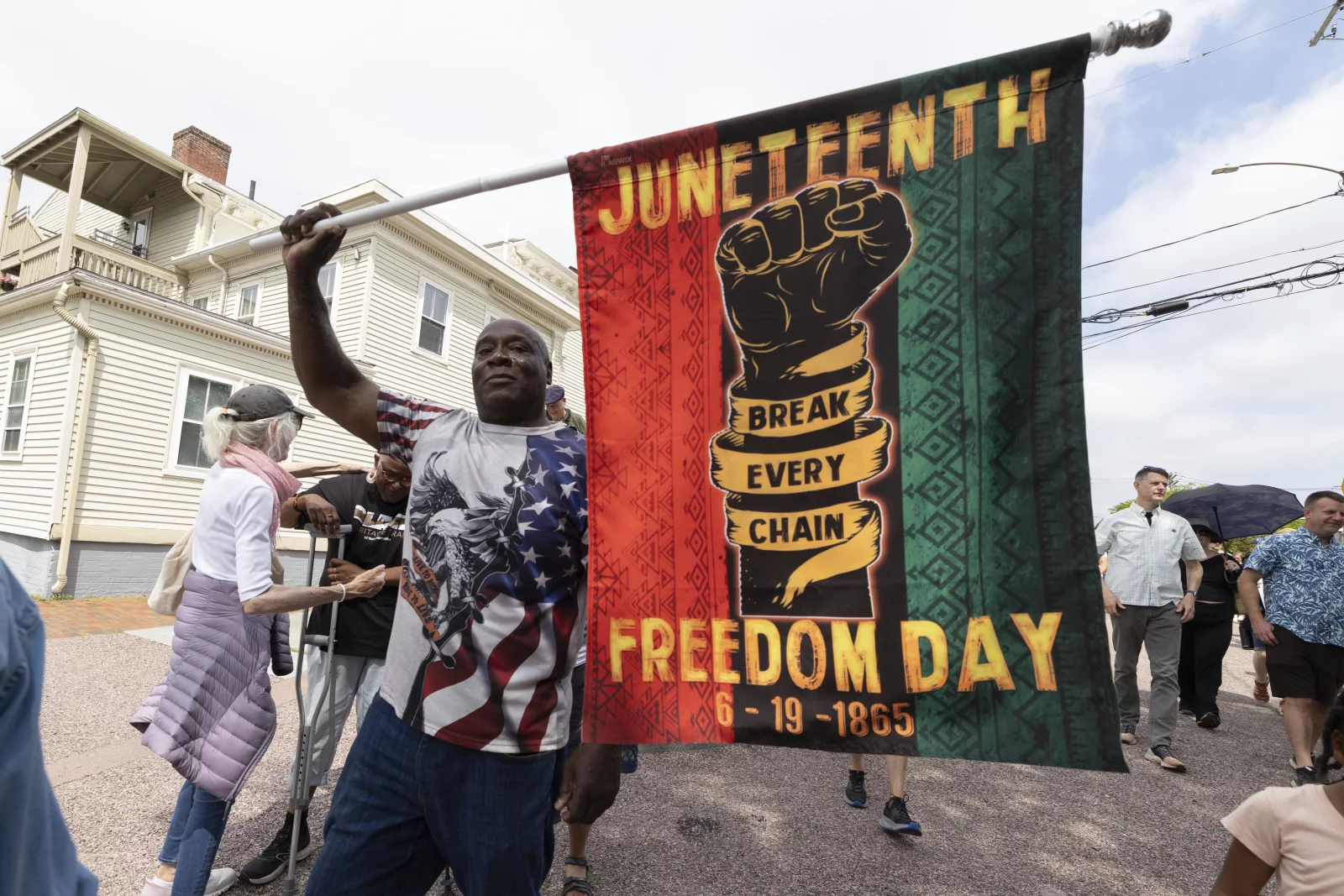 A man holds a Juneteenth celebration flag
