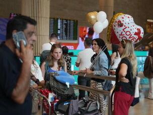 Holding balloons people wait for the arrival of passengers at Ben Gurion International Airport, near Tel Aviv, Israel, Wednesday.