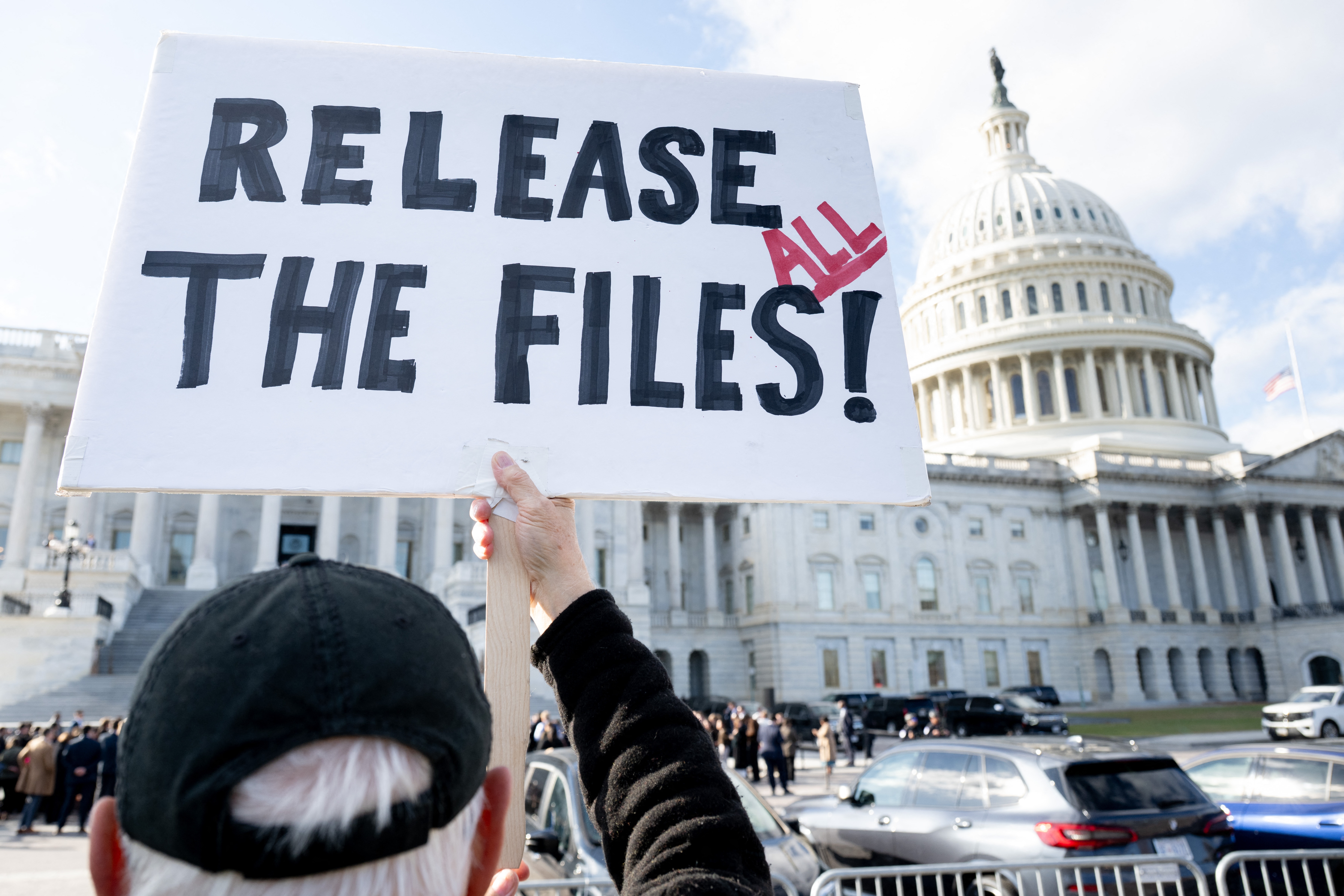 A protester holds a sign related to the release of the Jeffrey Epstein case files outside the U.S. Capitol on November 12, 2025. (AFP via Getty Images)