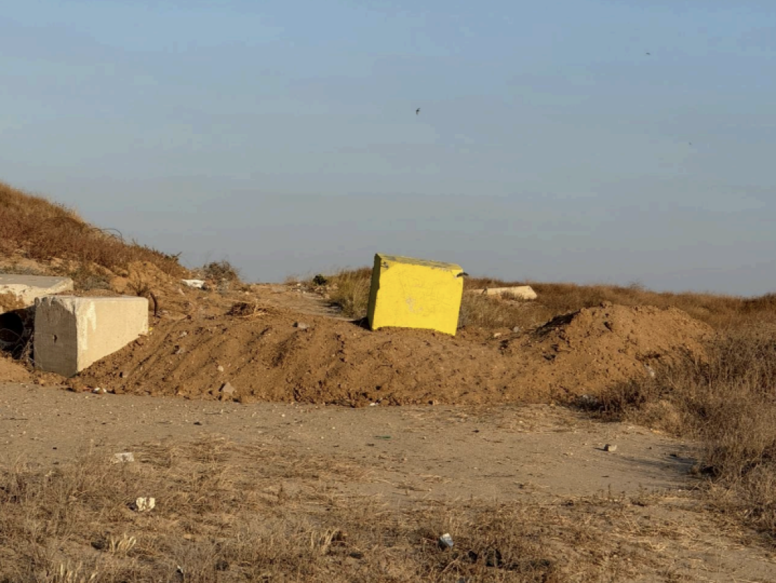 A yellow concrete block sits on a dirt berm marking an encroaching military boundary across Salah al-Din Street, Gaza's main road, as Israeli forces continue to advance their positions deeper into the territory.