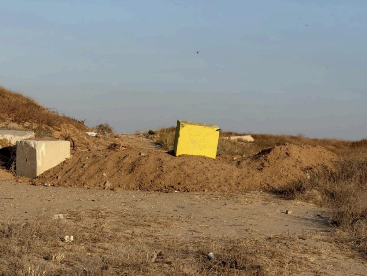 A yellow concrete block sits on a dirt berm marking an encroaching military boundary across Salah al-Din Street, Gaza's main road, as Israeli forces continue to advance their positions deeper into the territory.