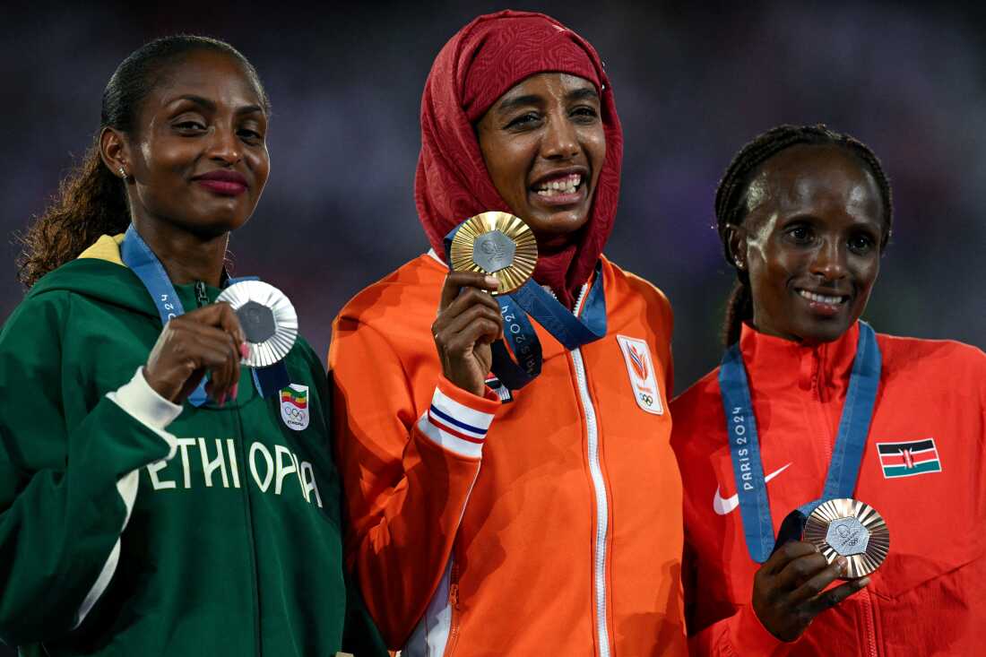 Silver medallist Ethiopia's Tigst Assefa, gold medallist Netherlands' Sifan Hassan and bronze medallist Kenya's Hellen Obiri pose during the podium ceremony for the women's marathon event on Sunday.